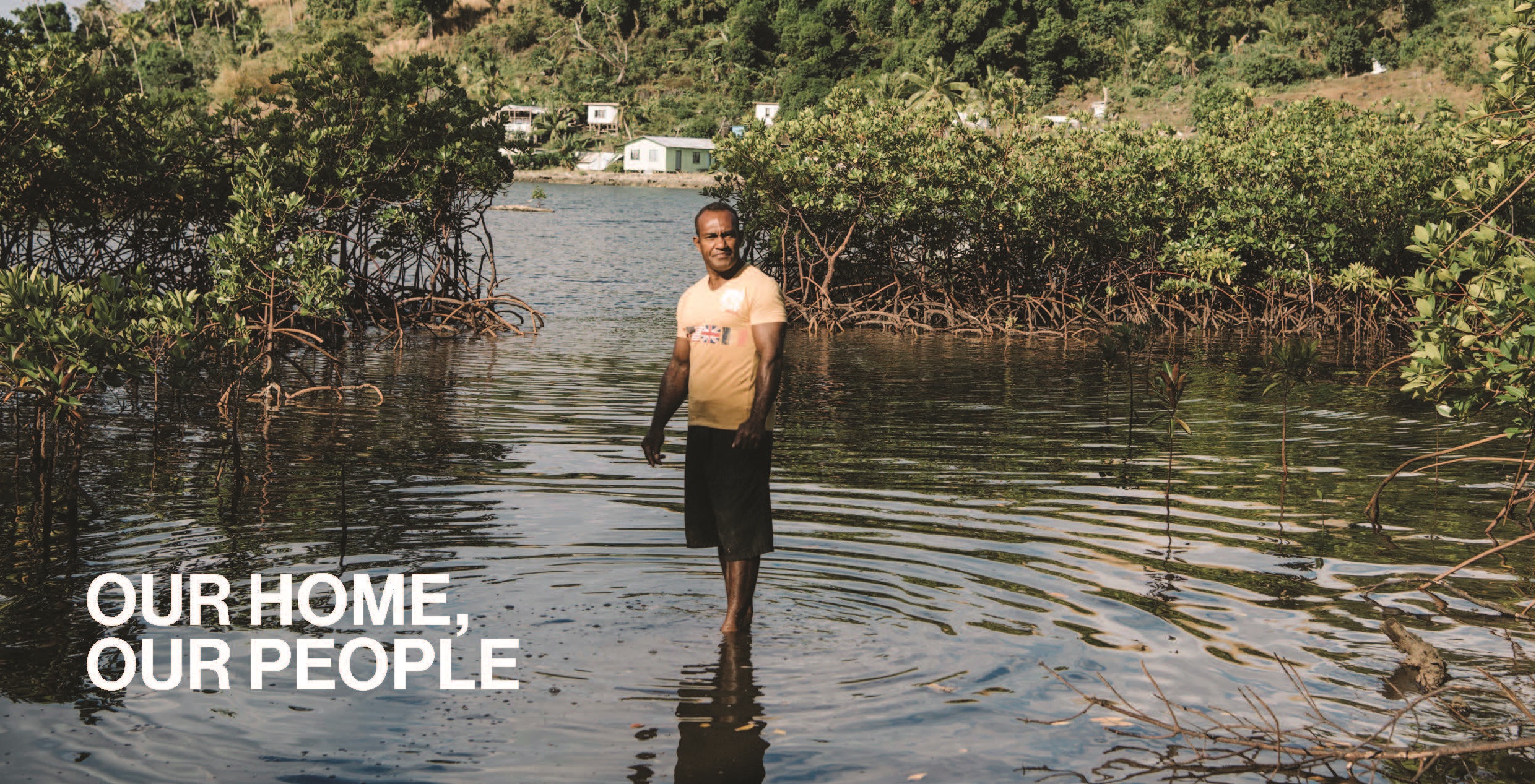 Fijian man standing in a flooded field in Fiji