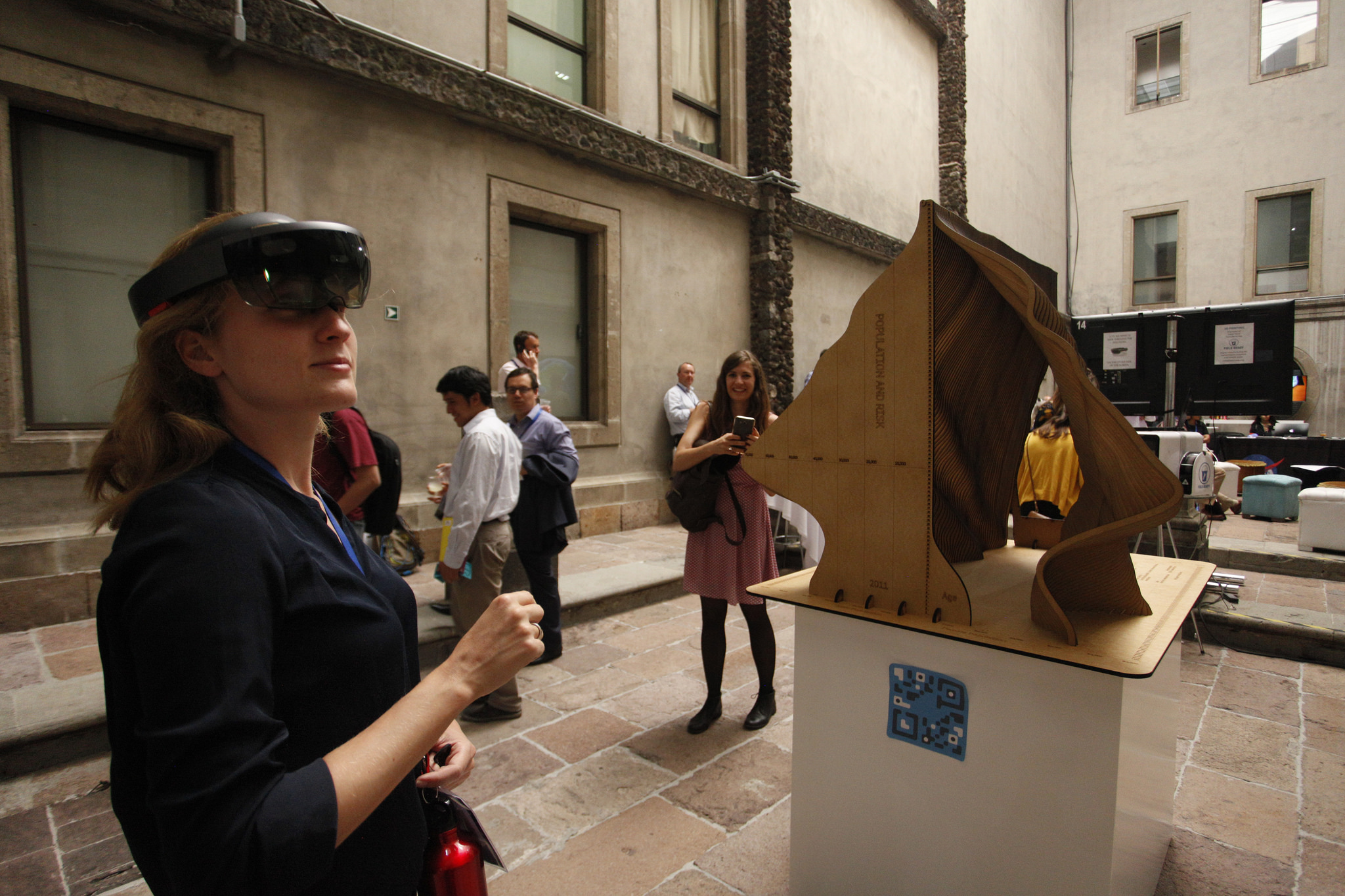 A participant using Augmented Reality (AR) glasses to explore a data sculpture. The sculpture captured data on age over the last century. (GFDRR)