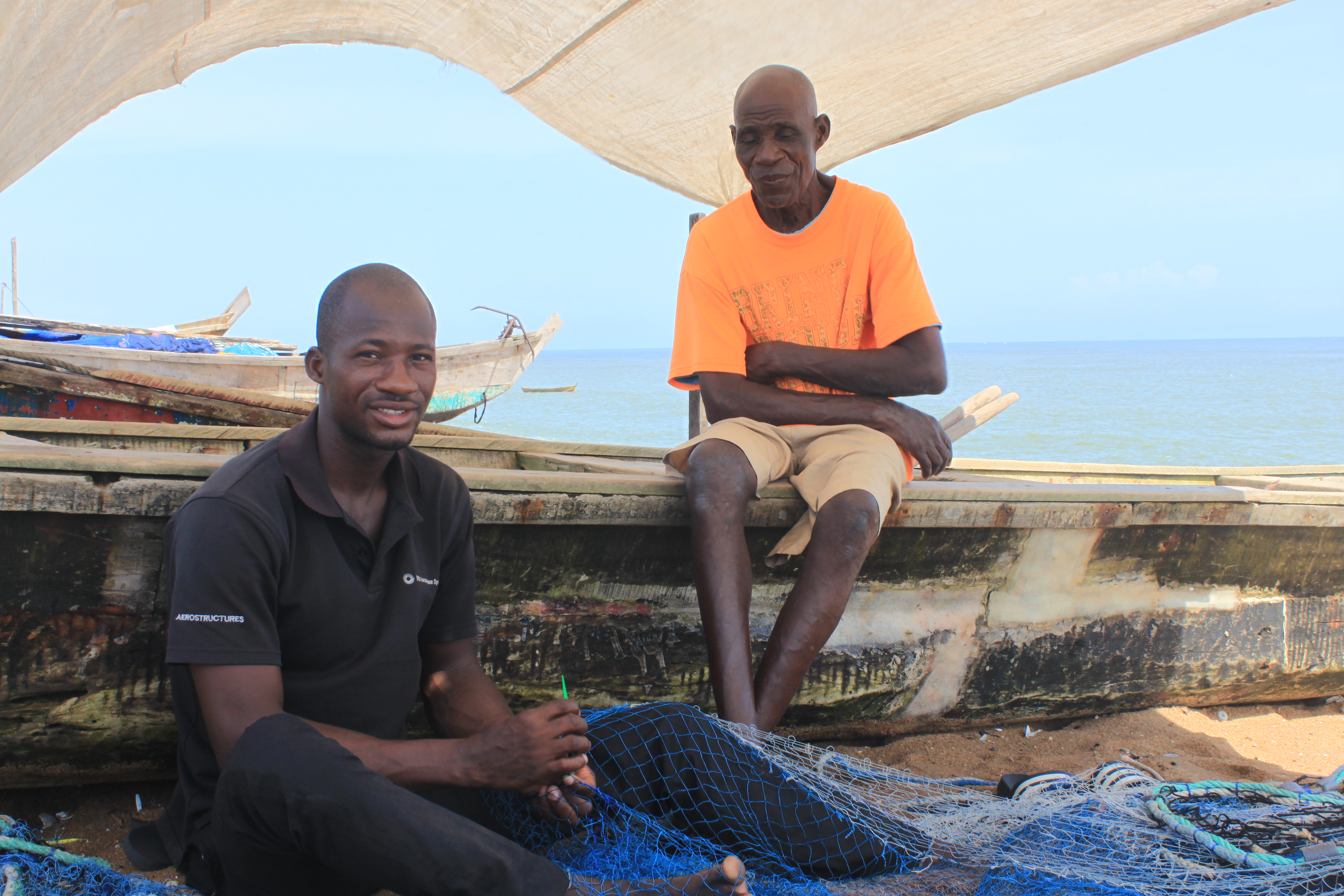 Fishermen work together, making nets to catch fish in Abidjan, Côte d'Ivoire