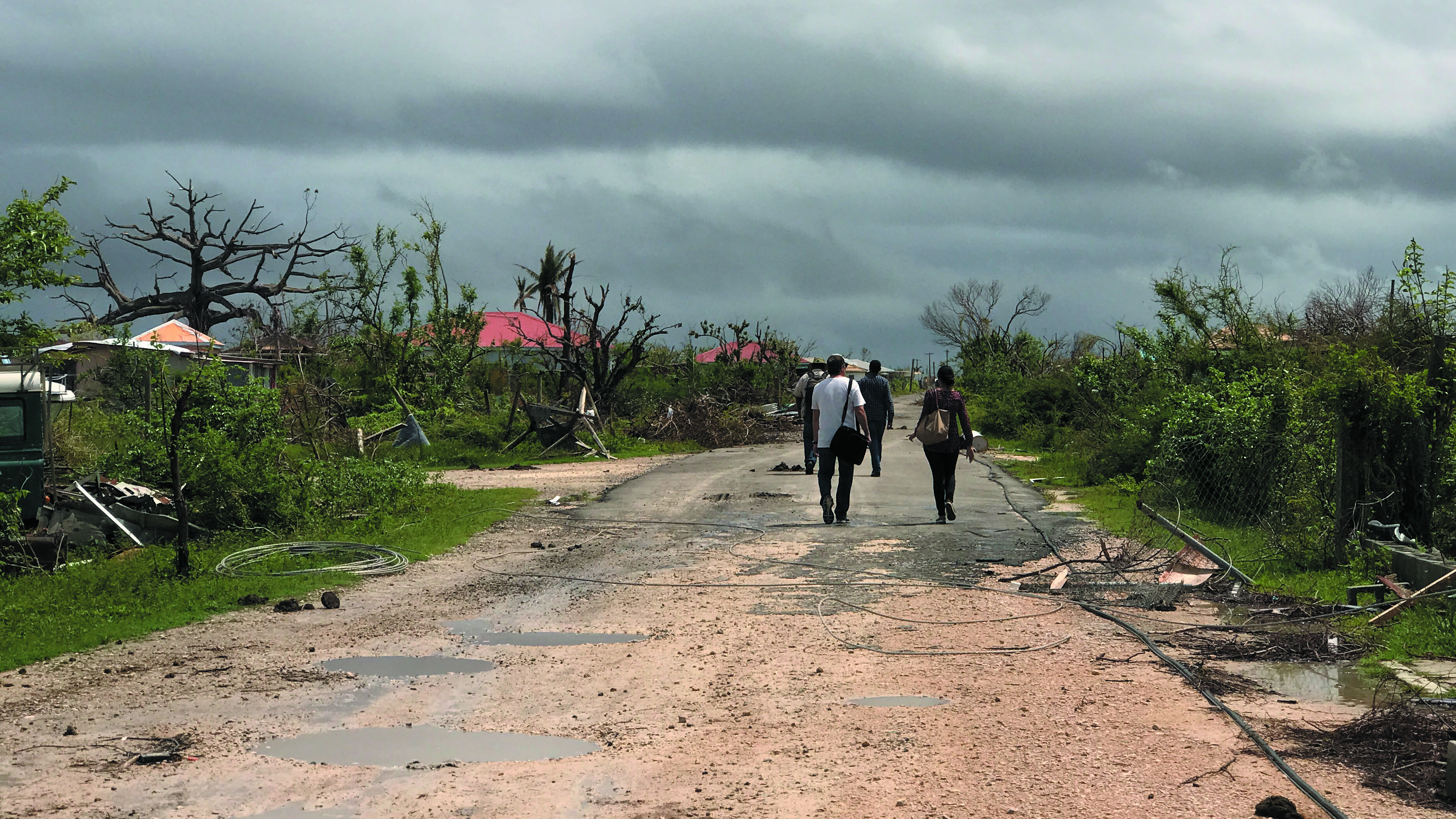 A group of people walk amid wreckage in Antigua and Barbuda
