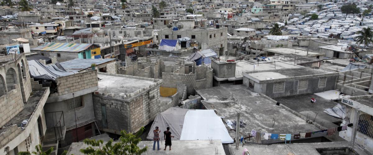 people standing on a rooftop looking over a neighborhood near port-au-prince haiti