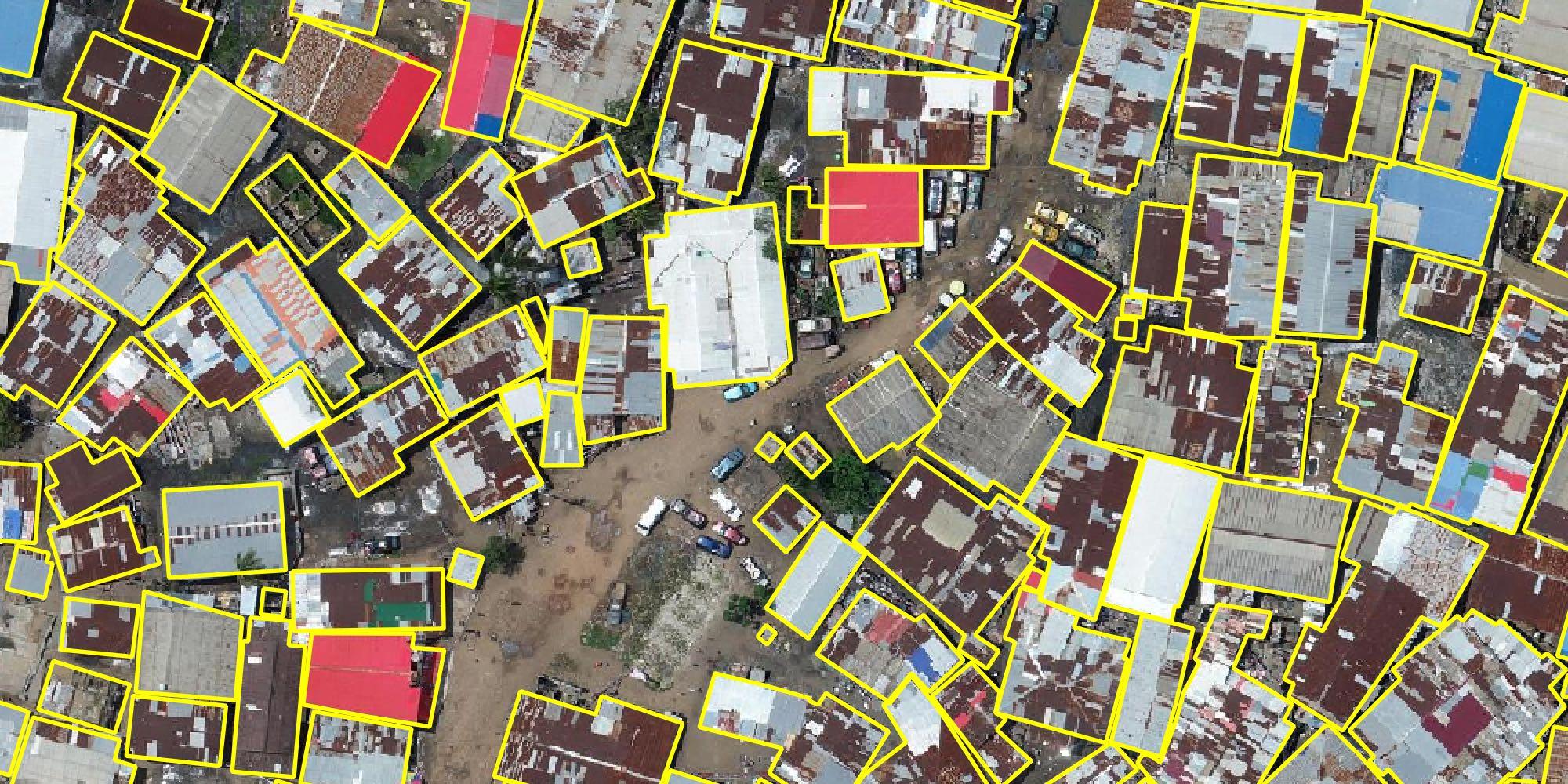 Aerial image of numerous buildings in a city, overlaid with yellow outlines to be used for digital mapping services.