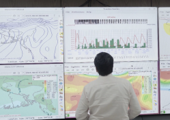 Meteorologist analyzes multi-panel weather forecasts for Bangladesh; Photo@S M Al Mahmud
